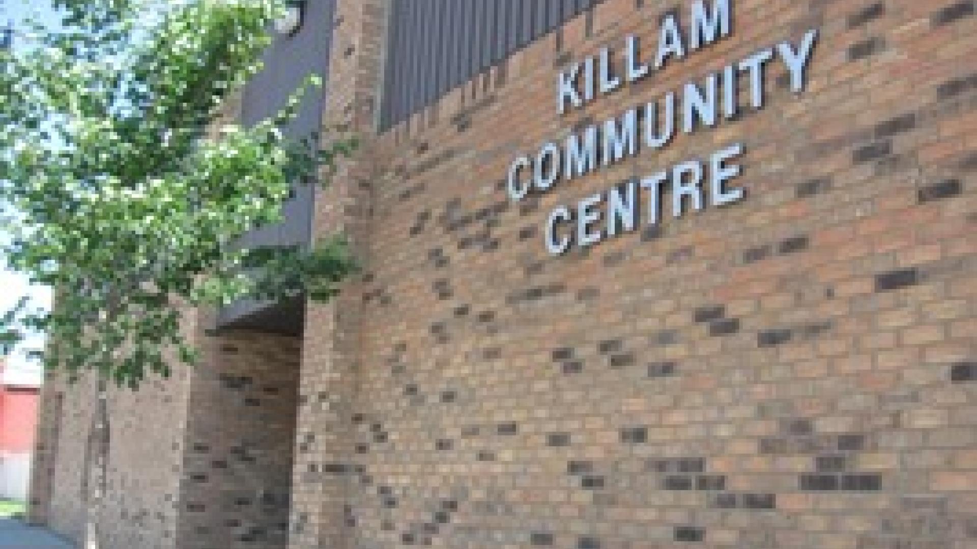 Exterior of Killam Community Centre. The building is made out of red brick and has lettering saying "Killam Community Centre" in a metal / silver colour.