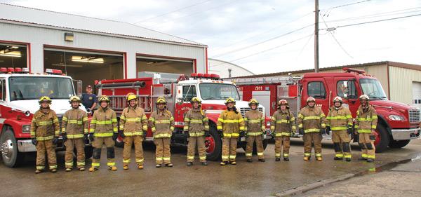 Killam volunteer Fire Department crew posing in front of fire station and fire turcks